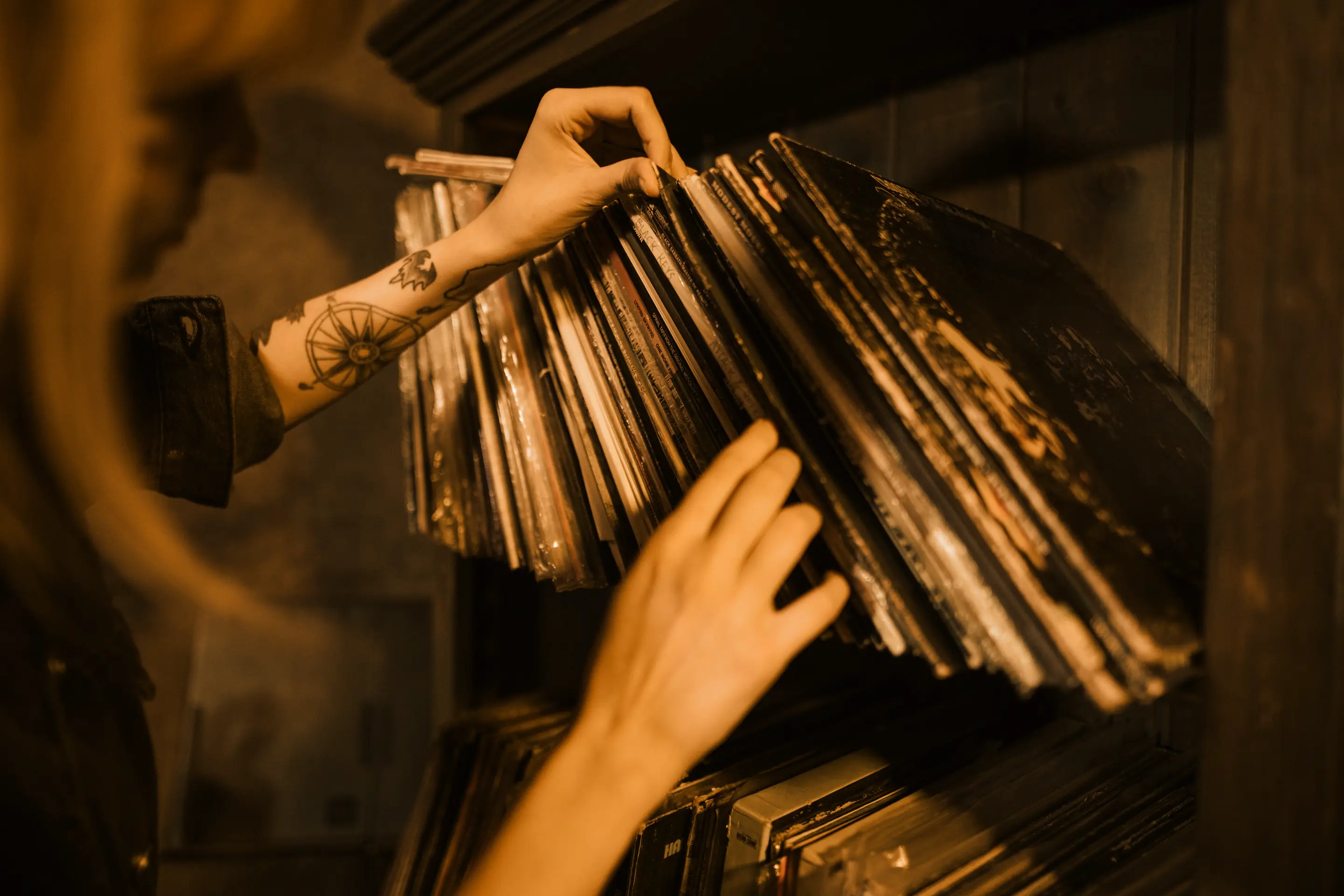 Hands flipping through a shelf of vinyl records