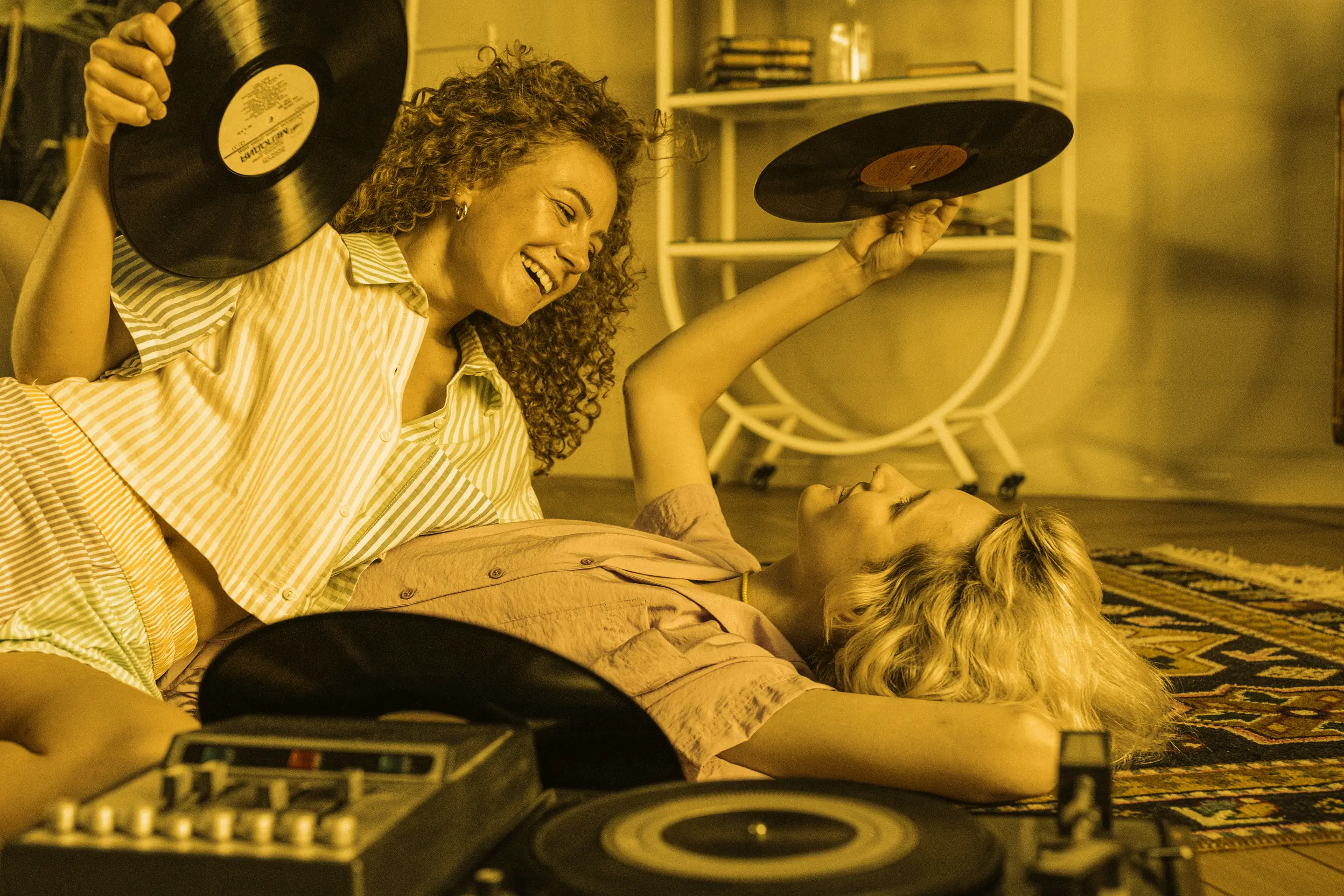 Friends laughing on the floor with their records and a turntable