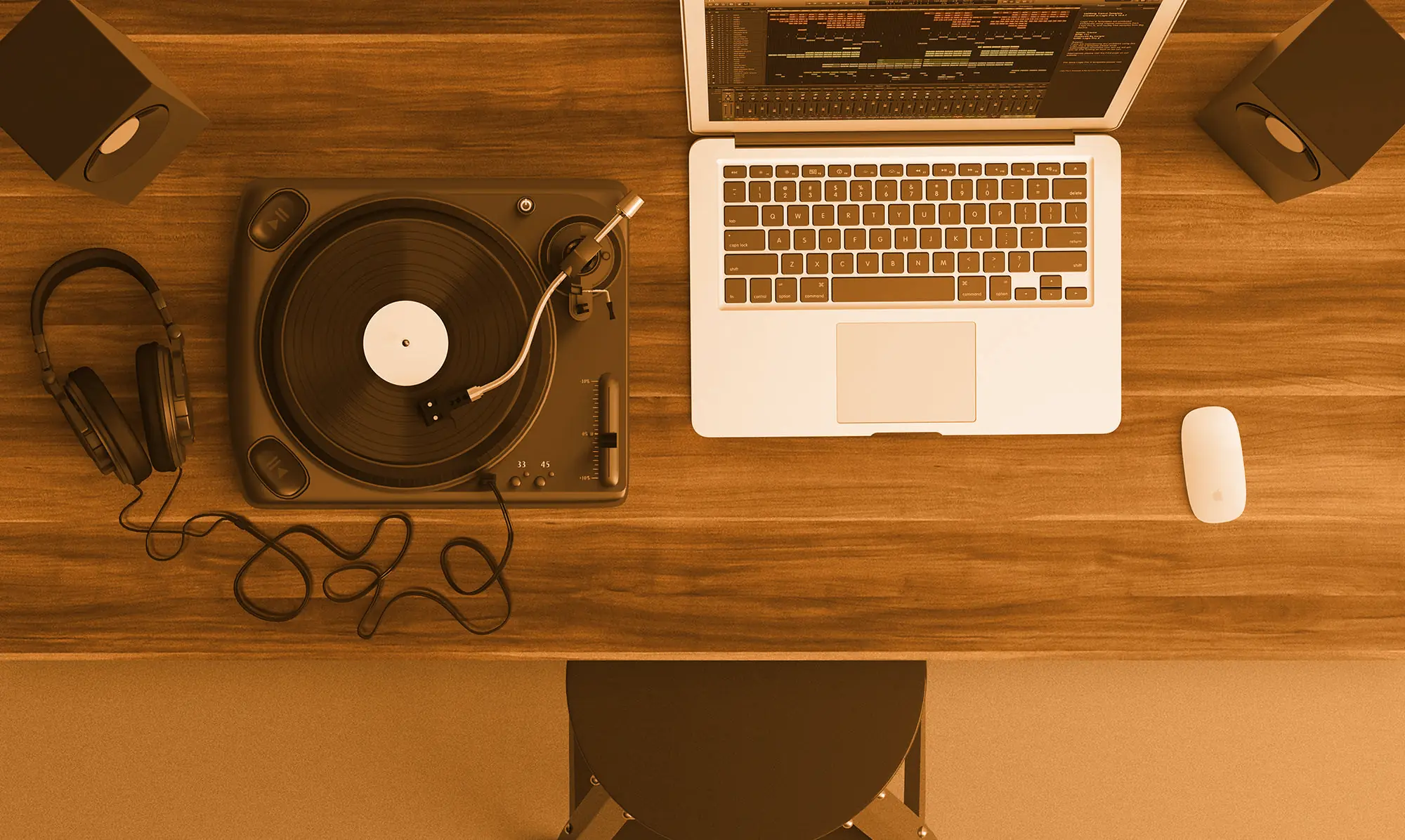 A turntable, headphones and a laptop on a wooden desk